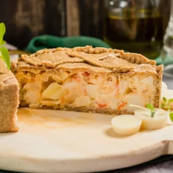 quiche de palmito sobre uma tabua de corte ao fundo um guardanapo verde e uma vasilha de óleo de oliva